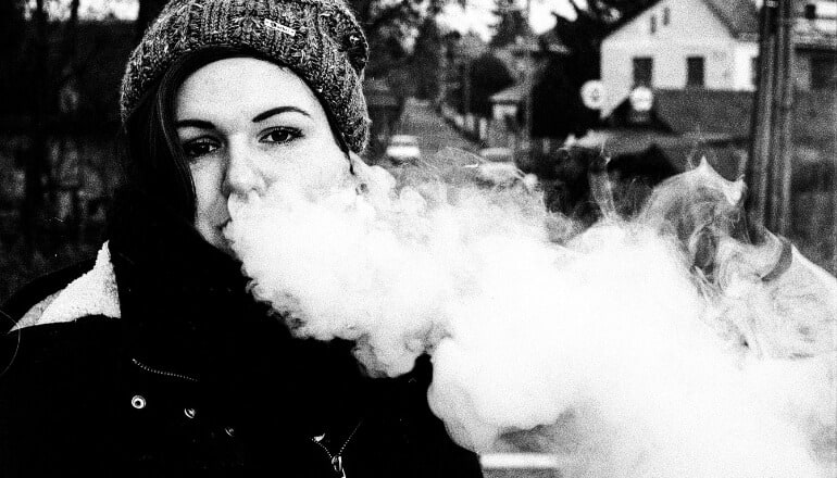 woman blowing vape