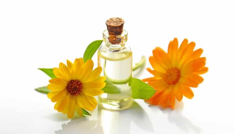 essential oils and yellow flowers on a table