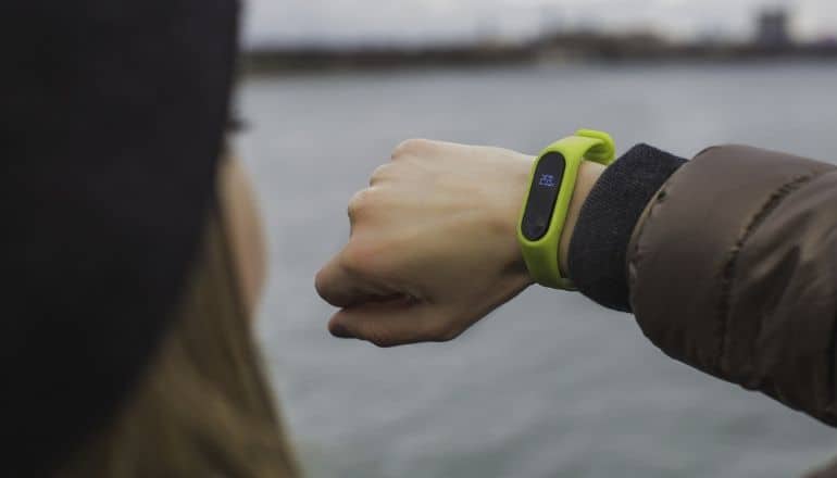 woman looking at a fitness tracker on her wrist