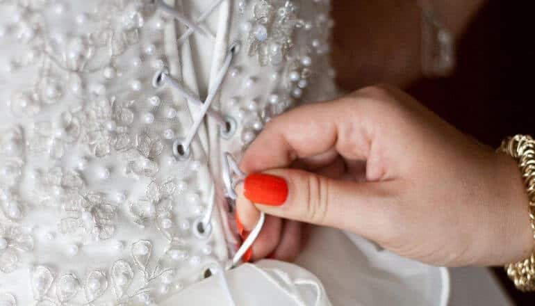 woman tightening string on wedding dress