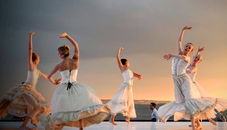 women in white dancing near water