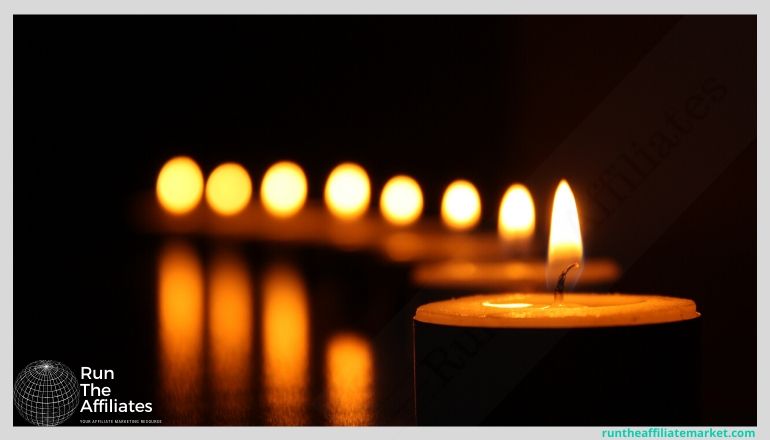 row of lit candles in the dark