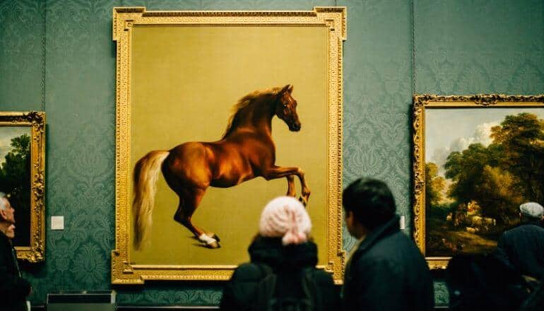 people looking at painting of horse