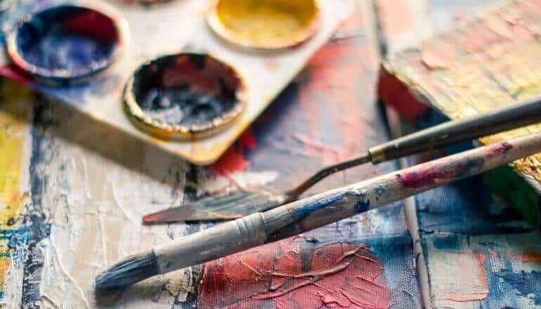 paint and paint brushes on wood table