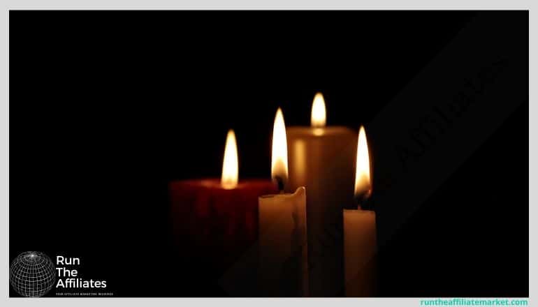 4 lit candles against a black background