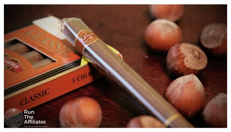 cigar laying on a table next to acorns