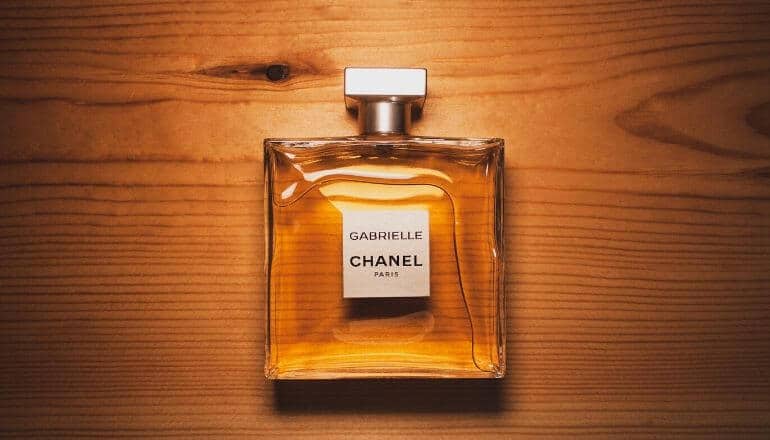 bottle of chanel grabrielle cologne sitting on a wood table, lying flat