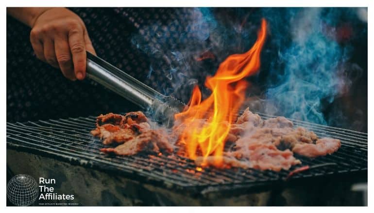 man grilling meats on an open flame