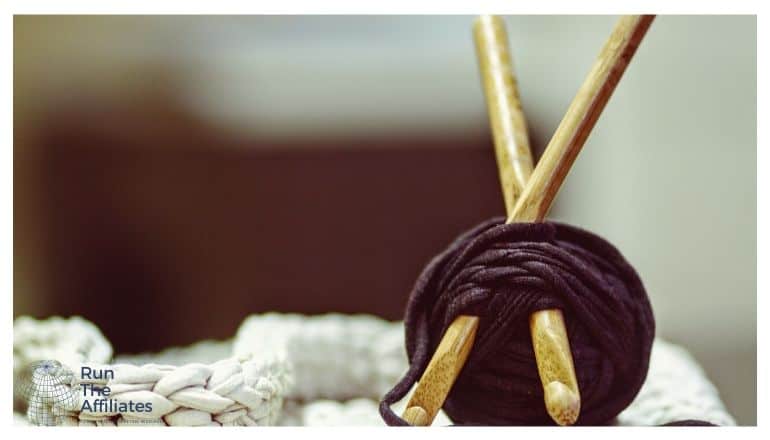 ball of brown yarn with knitting needles sticking into it