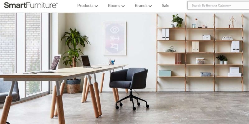 screenshot of the smart furniture website feartuing an office space with a small desk, chair and bookshelf next to a large window