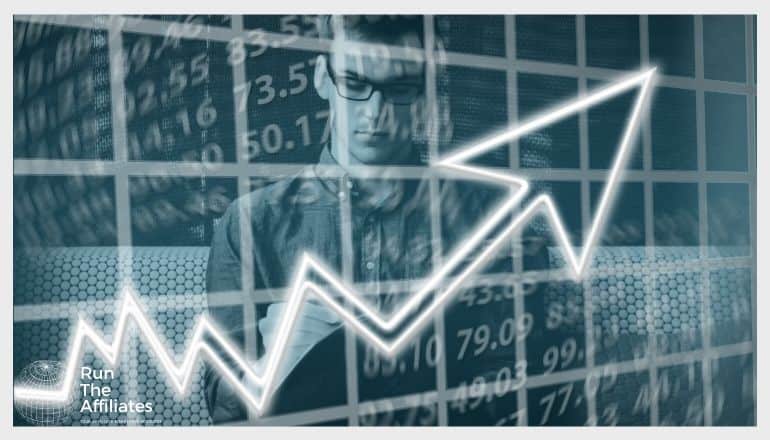 graph with arrow going up and man looking at the analytics