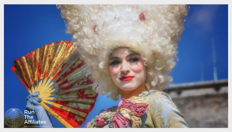 woman in white powder wig fanning herself