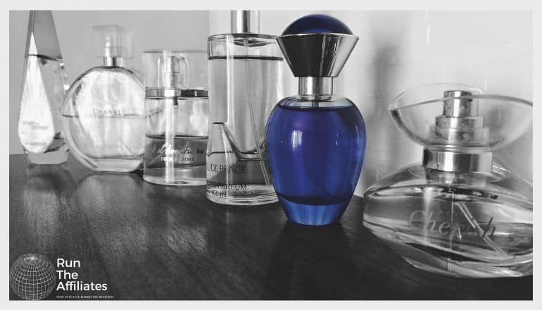 bottles of perfume on a counter in black and white with one bottle a deep blue in contrast