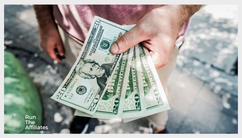 man holding 4 20 dollar bills of United States Currency