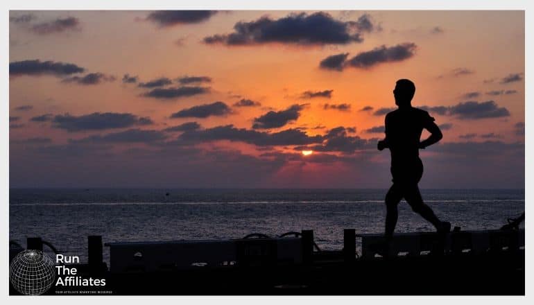 man running on a pier at sunset