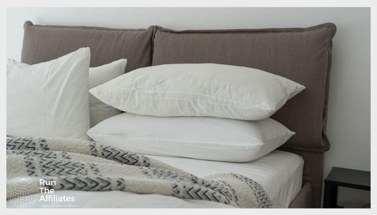 stack of white pillows on a grey bed