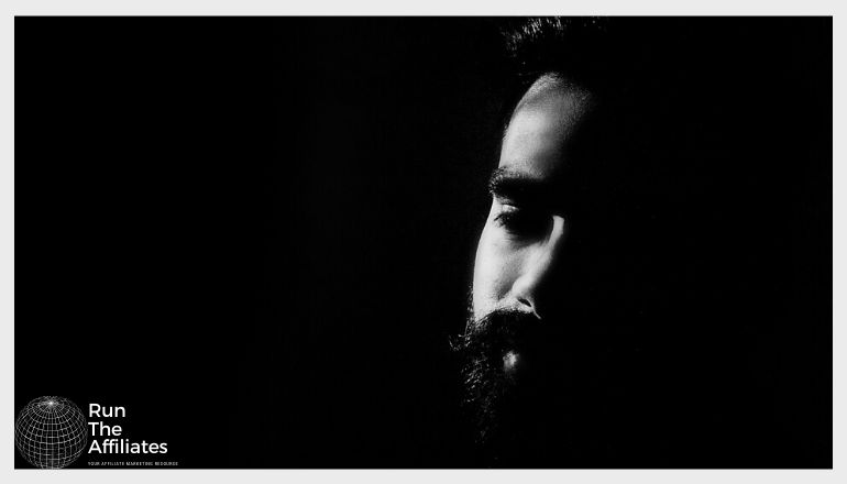 bearded man against a dark black background