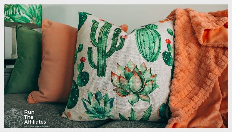 green and orange throw pillows with an orange blanket draped over a sofa