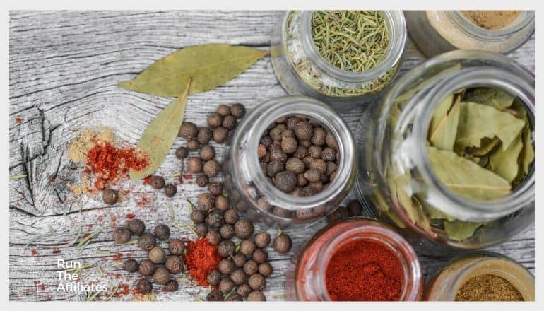 spices and herbs in mason jars sitting on a table