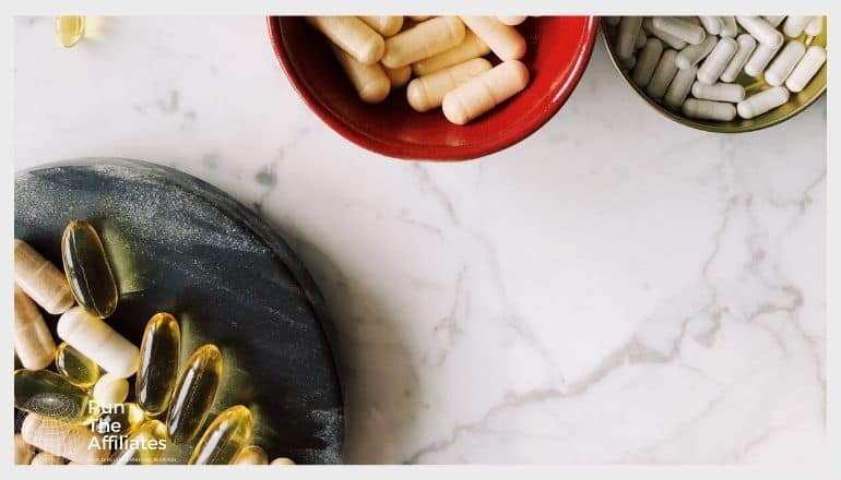 bowls of various supplements and vitamins on a marble counter top