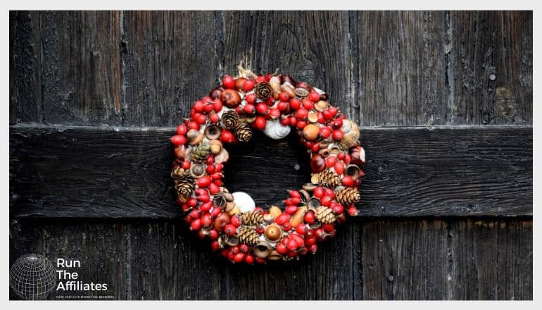 red wreath hanging on a wood door