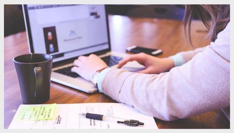 woman working on a marketing plan while sitting in from of a laptop