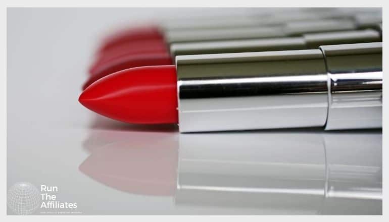 row of lipstick lying flat on a reflective white surface