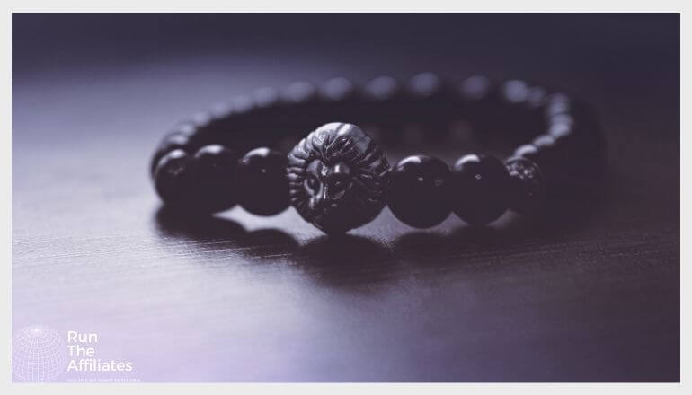 black bracelet with a lions head stone resting on a black table