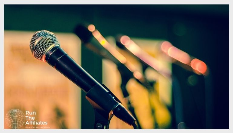 row of microphones on a stage