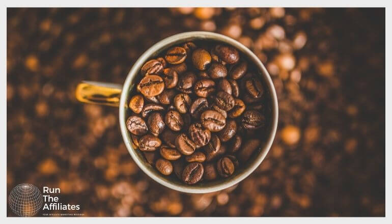 coffee cup filled with coffee beans on a bed of coffee beans