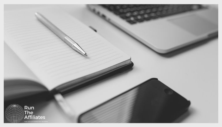 notpad and laptop on a desk in black and white