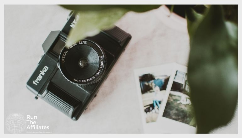 camera and photos with a plant in the foreground