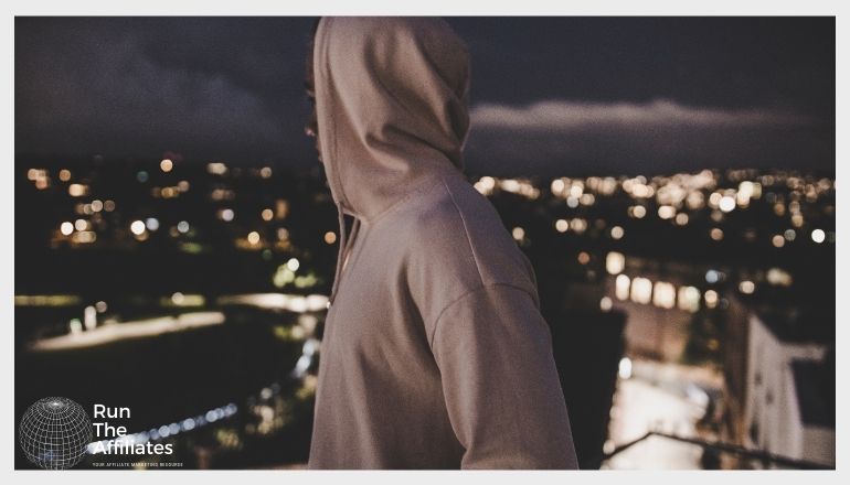 man in a hoodie overlooking an urban cityscape